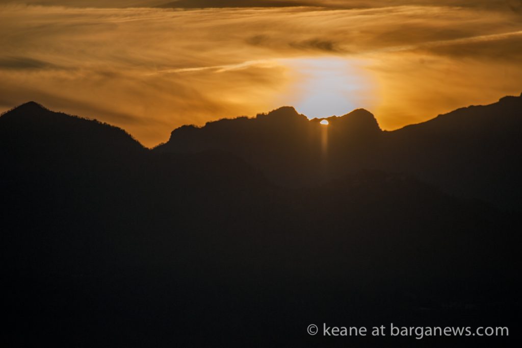Double sunset almost obscured by cloud
